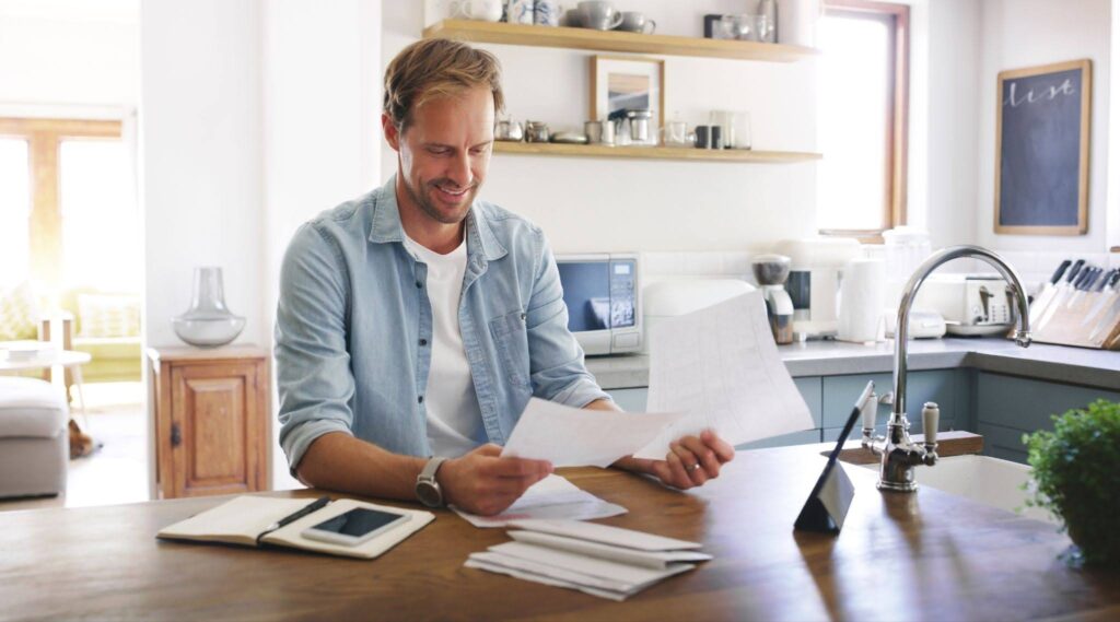 a smiling man checking documents