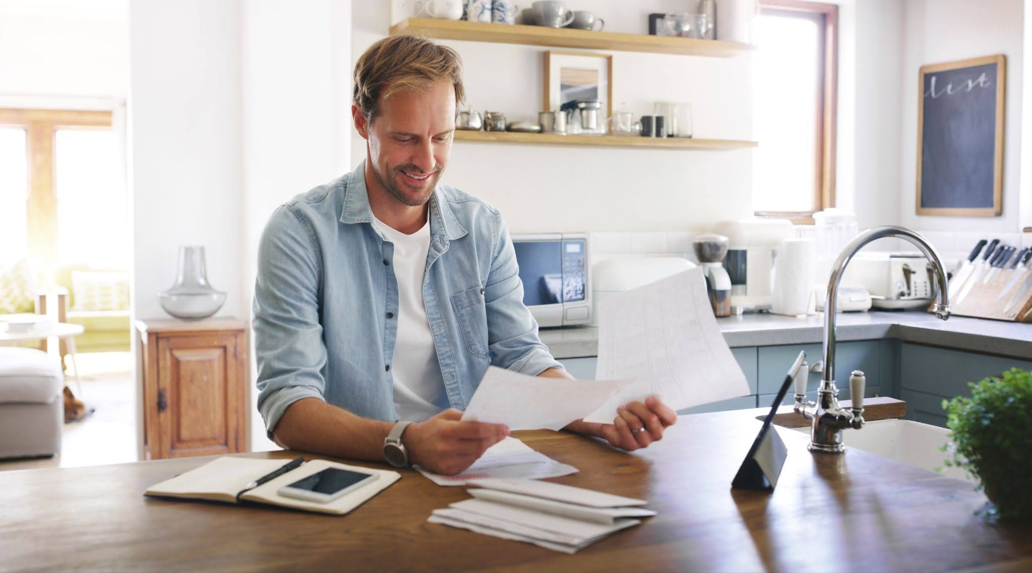 a smiling man checking documents