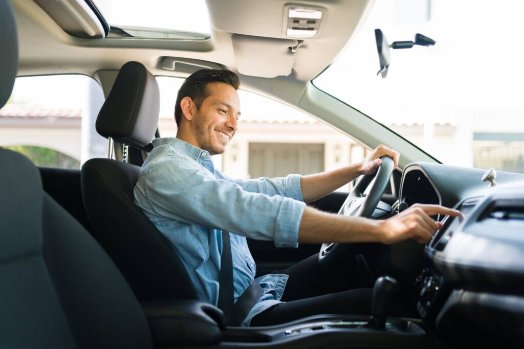 a male driver in the car using a touchscreen