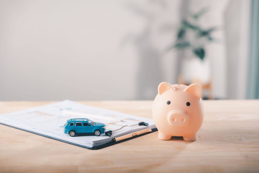 a piggy bank and a toy car on the stack of documents