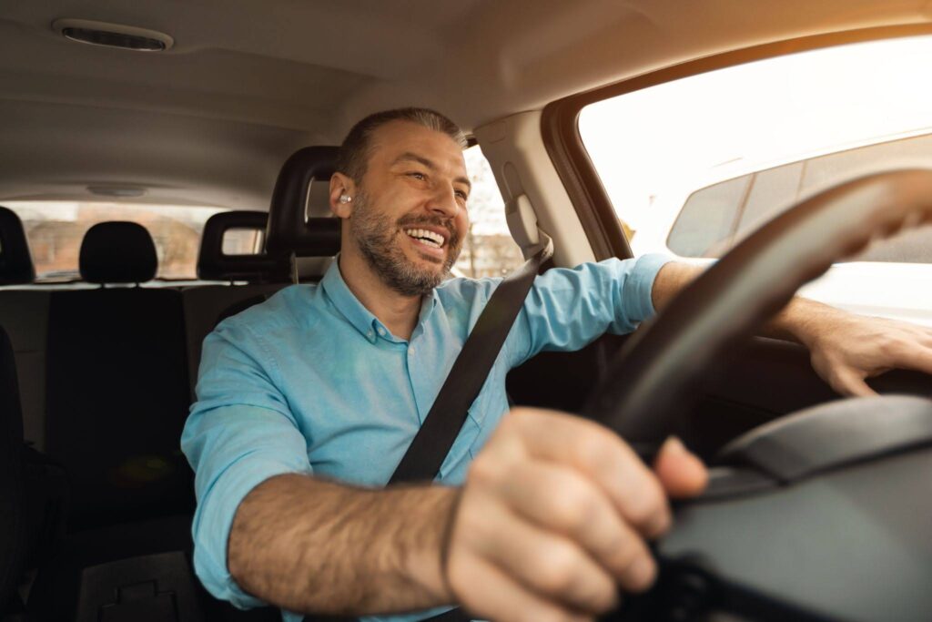 a happy man driving a car